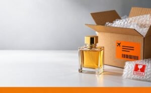 Can we send perfume by courier – perfume bottle beside a courier box ready for shipping